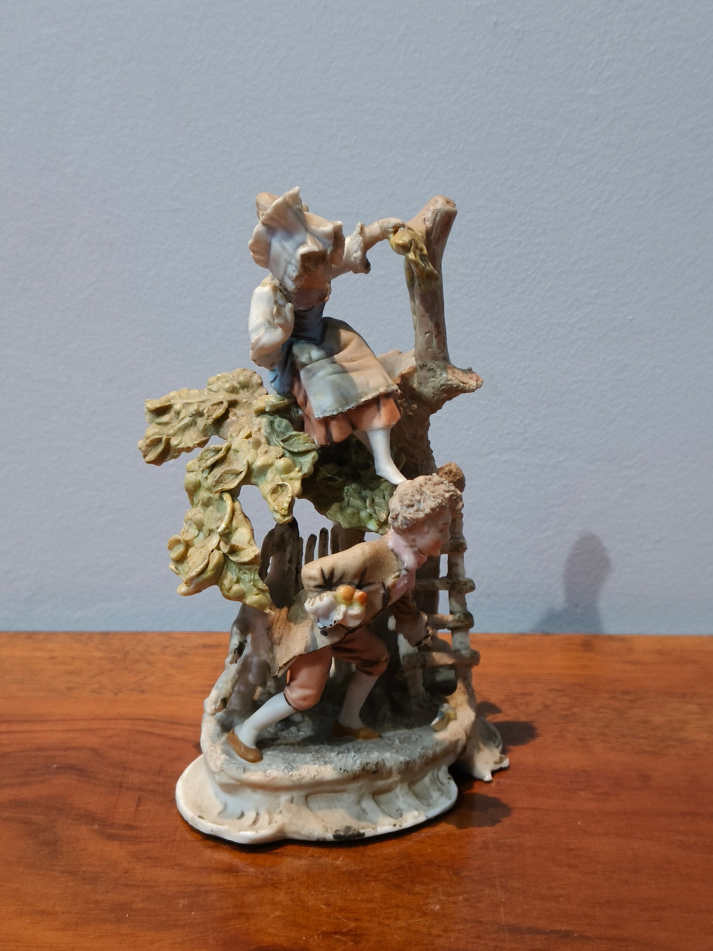 Figurka porcelanowa dzieci przy drzewie