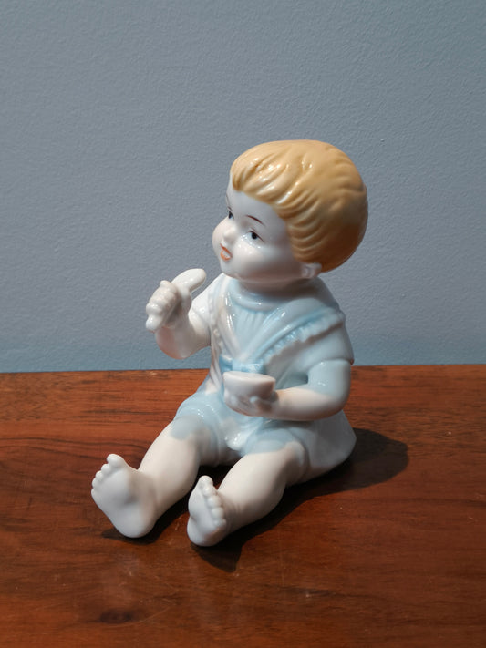 Figurka porcelanowa, szkliwiona, dziecko z łyżką