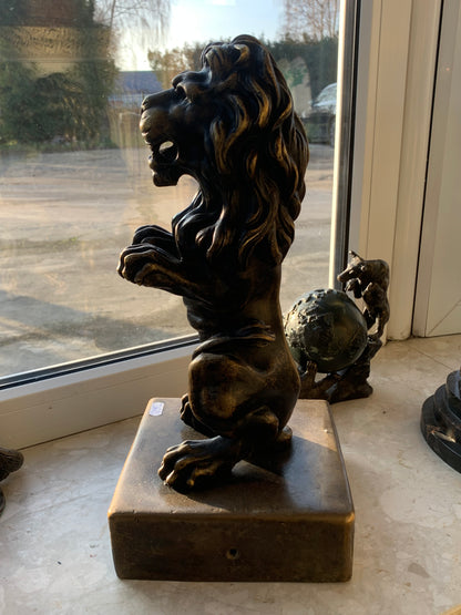 Bronze sculpture of a lion on a base