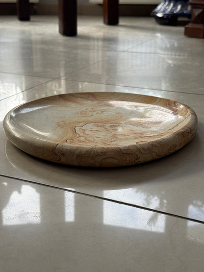 A decorative plate made of sandstone